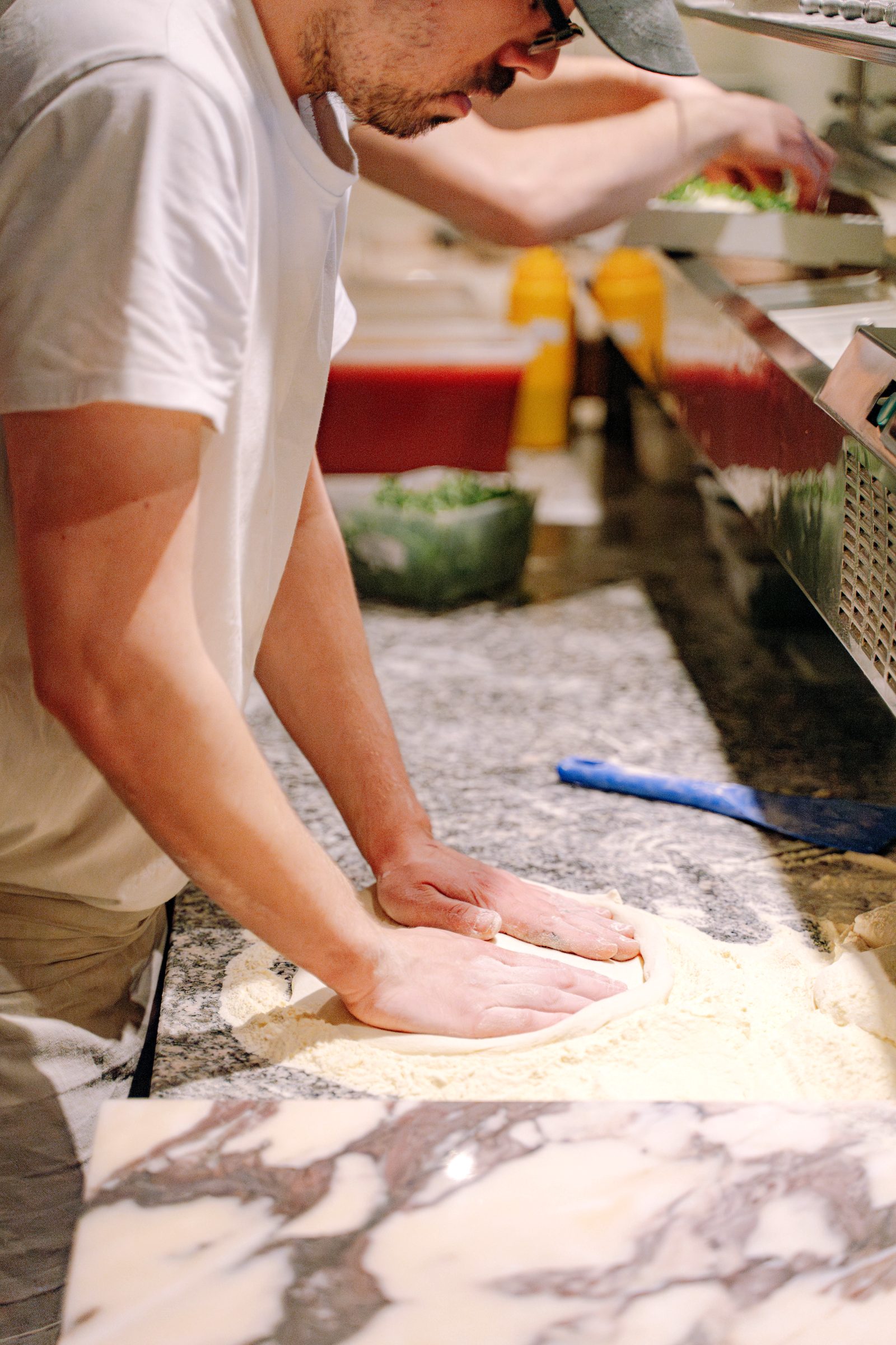 La pâte à pizza travaillée à la main sur le marbre