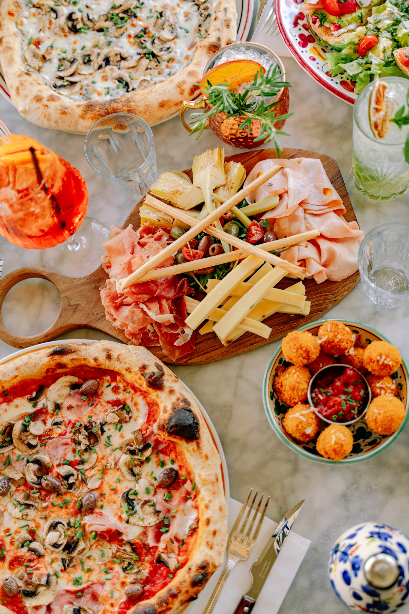 Une tablée de pizzas et d'antipasti partagés chez Pozzi Nonni